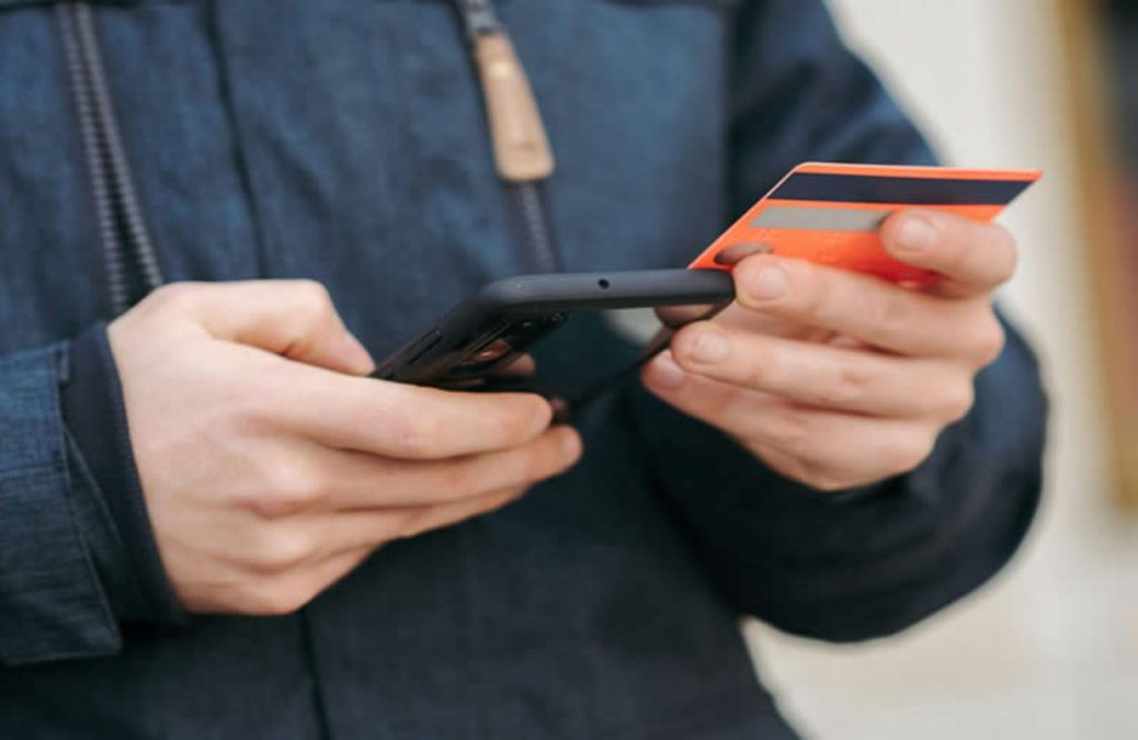 Uomo che fa un bonifico bancario con lo smartphone