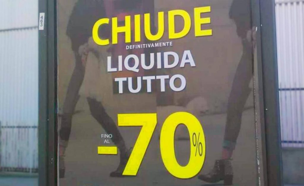 Cartello liquidazione totale su vetrina negozio di abbigliamento