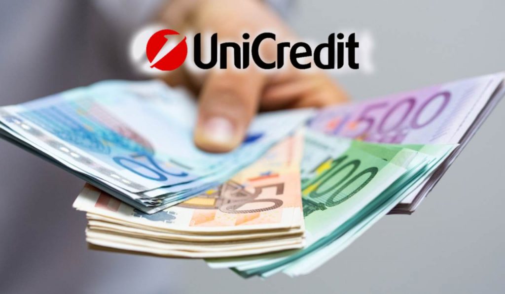 Uomo con in mano tante banconote euro e scritta "Unicredit"