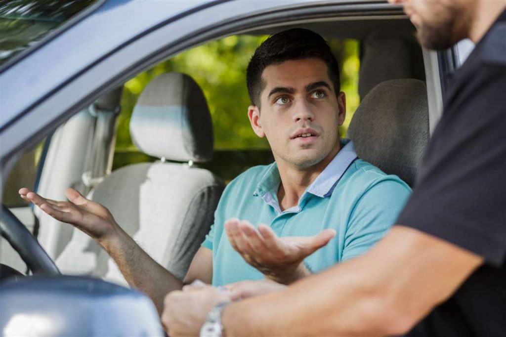 Uomo al volante che parla con le autorità stradali